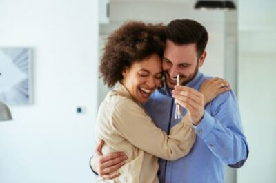 Couple holding a house key, celebrating about their new home