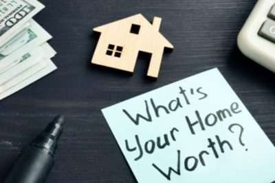 What's your home worth? sign and a small house model